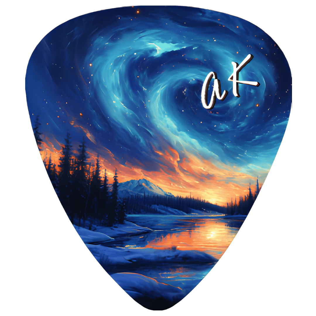 A guitar pick featuring a detailed fantasy landscape illustration with a swirling blue and teal starry sky, snowy mountains, pine trees, and an orange sunset reflected in a river. A stylized white 'ak' signature is printed in the upper right.