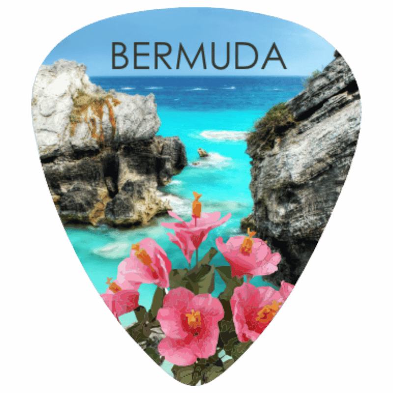 A guitar-pick-shaped Bermuda travel print featuring a scenic coastal view with turquoise water, rocky cliffs, and pink flowers, with the word BERMUDA printed at the top.