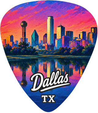 A guitar pick shaped like the Dallas skyline at sunset, with a colorful cityscape over water and the words 'Dallas TX' printed near the bottom.