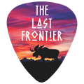 A guitar pick featuring a colorful sunset landscape design with the text 'THE LAST FRONTIER' and a black moose silhouette over mountains.