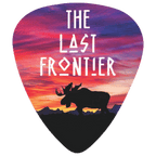 A guitar pick featuring a colorful sunset landscape design with the text 'THE LAST FRONTIER' and a black moose silhouette over mountains.