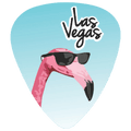 A guitar pick featuring a pink flamingo wearing black sunglasses against a light blue gradient background, with the words 'Las Vegas' in black script and white outline near the top.