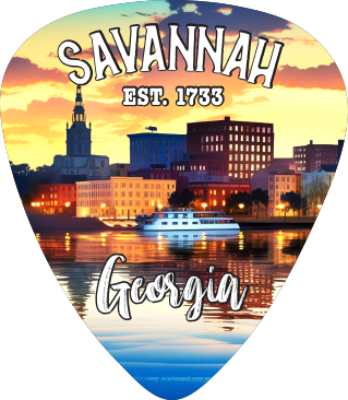 A guitar-pick-shaped souvenir charm featuring a Savannah, Georgia skyline at sunset with a boat on the water, and the text 'SAVANNA EST. 1733' and 'Georgia'.